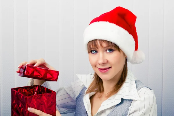 Meisje in het kantoor in Santa hoeden met een geschenk — Stockfoto