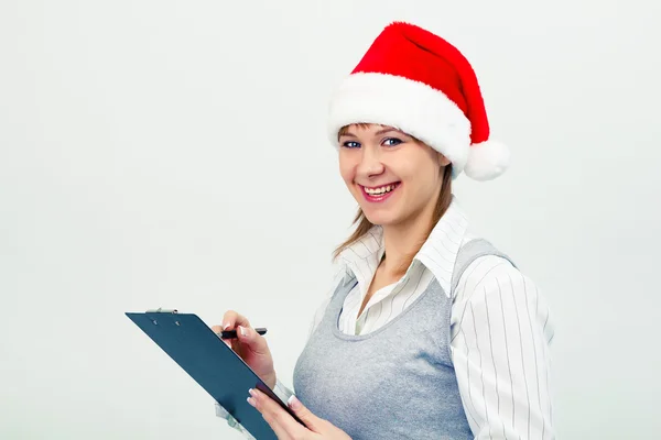 Glückliches Mädchen mit Weihnachtsmütze und Notizbuch — Stockfoto