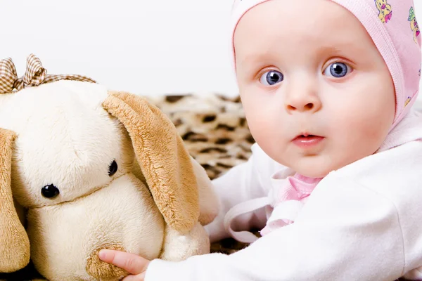 Bébé aux yeux bleus avec un jouet doux. studio photo — Photo