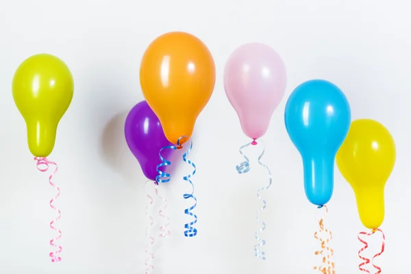 Balões de cores brilhantes diferentes em um fundo branco — Fotografia de Stock