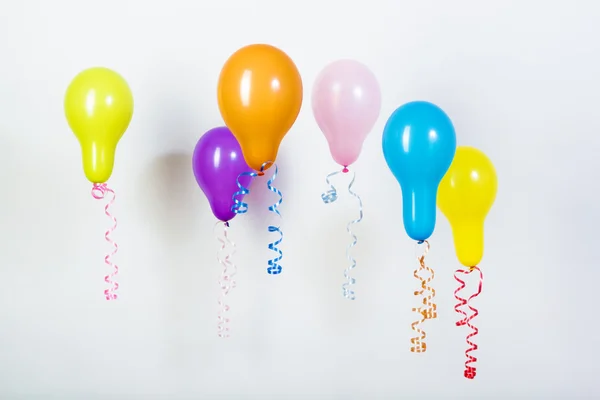 Balões de cores brilhantes diferentes em um fundo branco — Fotografia de Stock