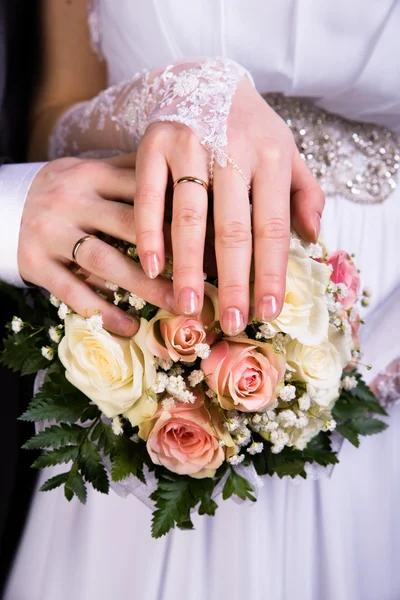 Mani degli sposi con bouquet da sposa — Foto Stock