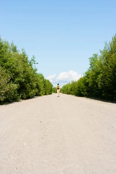 Man with a backpack goes on the sandy road. traveler — Stock Photo, Image