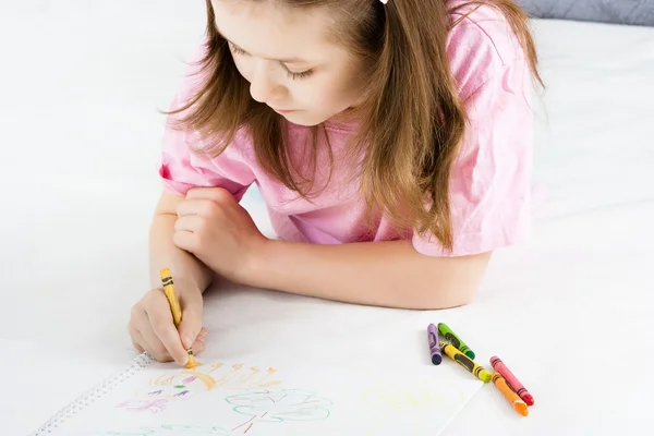 Menina desenha deitado no chão — Fotografia de Stock