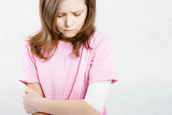 Una chica con un vendaje en la mano. lesiones en los miembros — Foto de Stock