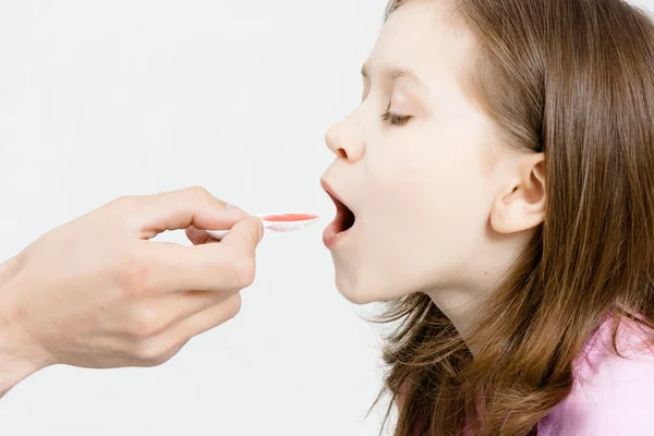 Çocuğun tedavi. Kız tıbbi şurubu içiyor