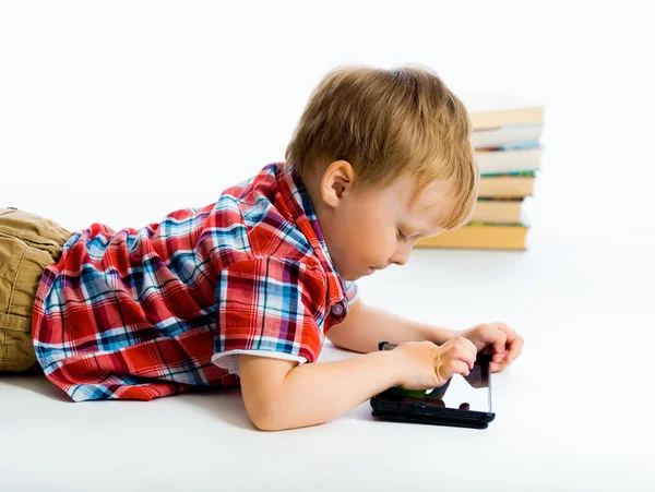 Хлопчик лежить на підлозі з планшетним комп'ютером — стокове фото