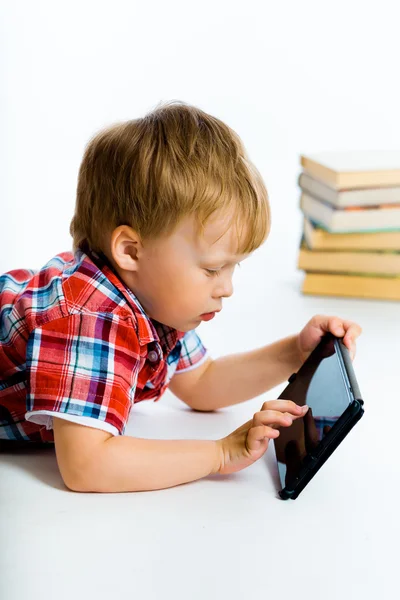 Boy lying on the floor with tablet computer — Stockfoto