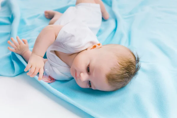 Baby lying on a blue blanket — Zdjęcie stockowe