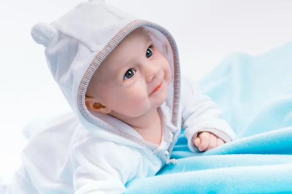 Baby in the hood on a blue blanket — Stock Photo, Image