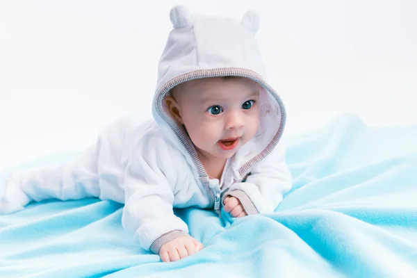 Bébé dans le capot sur une couverture bleue — Photo