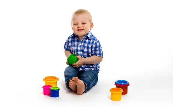 Bebé feliz en una camisa a cuadros con juguetes. estudio — Foto de Stock