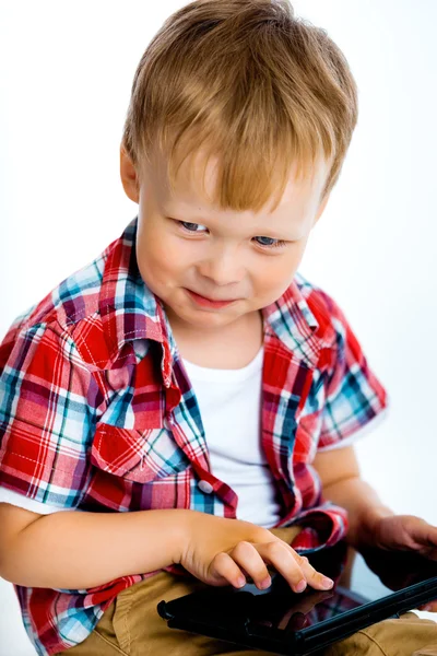 Улыбающийся мальчик с планшетным компьютером — стоковое фото