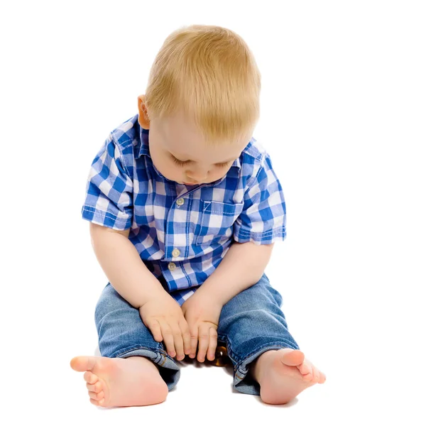 Niño pequeño en una camisa a cuadros y jeans — Foto de Stock