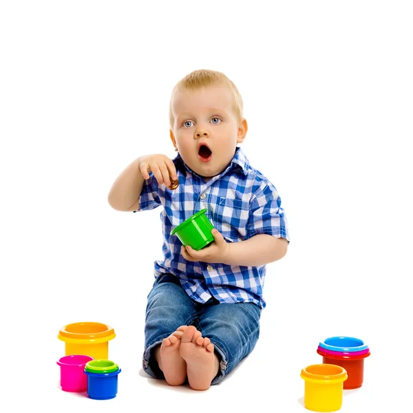 Niño pequeño con juguetes sobre un fondo blanco — Foto de Stock