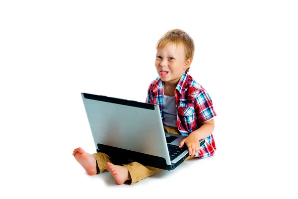 Kleine jongen met een laptop zittend op de vloer — Stockfoto