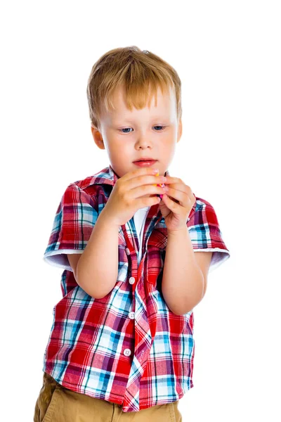 Liten pojke står och undersöker liten leksak — Stockfoto