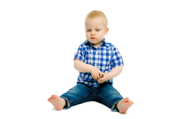 Jongen zittend op een witte vloer — Stockfoto