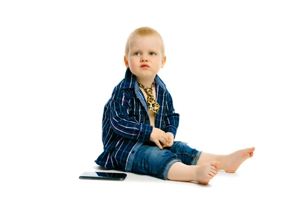 Boy in a tie sitting on a white floor — Stock Photo, Image