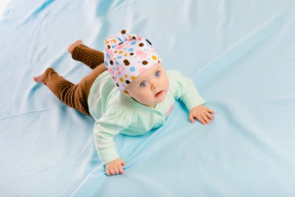 Bebê de olhos azuis no chapéu rastejando — Fotografia de Stock