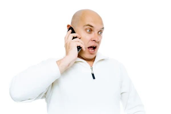 Homem careca se comunica emocionalmente por telefone. Isolado. Estúdio — Fotografia de Stock