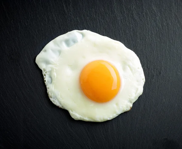 Fried egg on black background — Stock Photo, Image