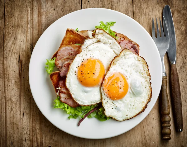 Oeufs frits sur assiette blanche — Photo