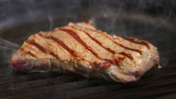 Bife de vaca é frito em uma panela de churrasqueira fumegante quente — Vídeo de Stock