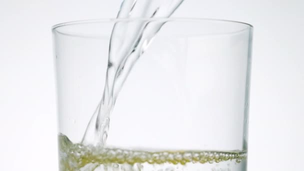 Detailní záběr studené čerstvé nehybné vody nalévající se do sklenice s citronovými plátky, zpomalený pohyb — Stock video