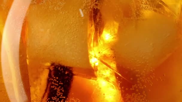 Close up of orange cocktail with ice cubes drinking with a straw slow motion — Stock Video