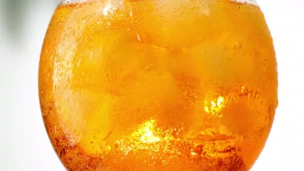 Molhado laranja gelo coquetel vidro closeup girando no fundo branco — Vídeo de Stock