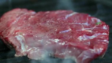 Sıcak ızgarada ızgara edilmiş çiğ biftek.