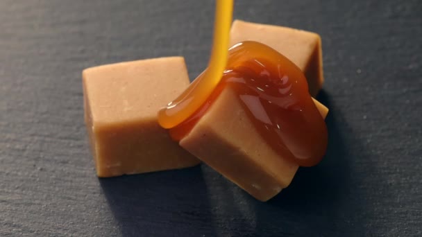 Geschmolzene Karamellsoße Fließt Auf Karamellbonbons Nahaufnahme — Stockvideo