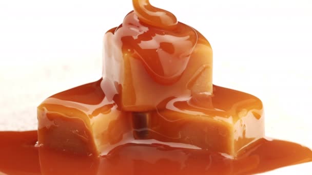 Roztopiony sos karmelowy płynący na cukierki karmelowe zbliżenie — Wideo stockowe