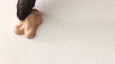 beige smear of tonal foundation cream close up, smudge with a brush, beautiful pastel texture, cosmetic product for make up