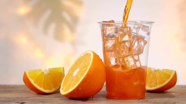 Čerstvý Pomerančový Nealkoholický Nápoj Plastovém Kelímku Kostkami Ledu Rozostřenými Světly — Stock video