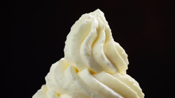 Colorful sugar sprinkles pouring on to rotating whipped cream swirl close up macro — Stock Video