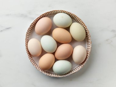 Mutfak masasının üstünde taze çiğ biyolojik yumurta kasesi.