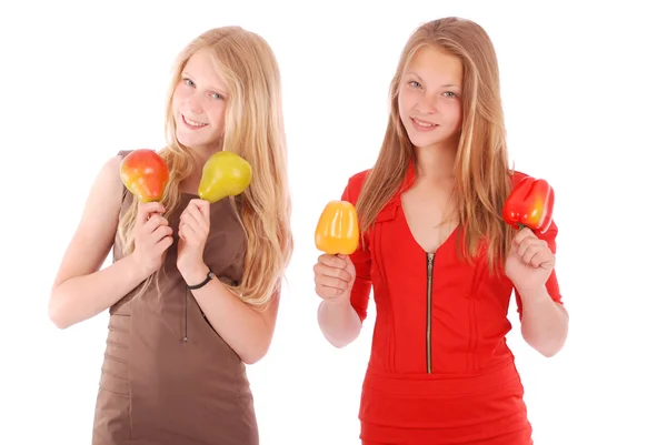 Junges Mädchen hält neben dem Gesicht Äpfel und Birnen — Stockfoto