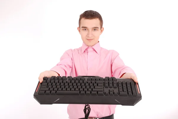 Улыбающийся подросток с компьютерной клавиатурой — стоковое фото