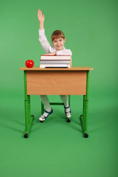 Fille dans un uniforme scolaire assis à un bureau — Photo