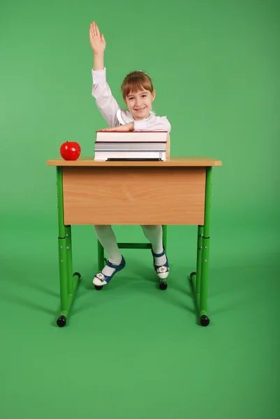 Ragazza in uniforme scolastica seduta a una scrivania — Foto Stock