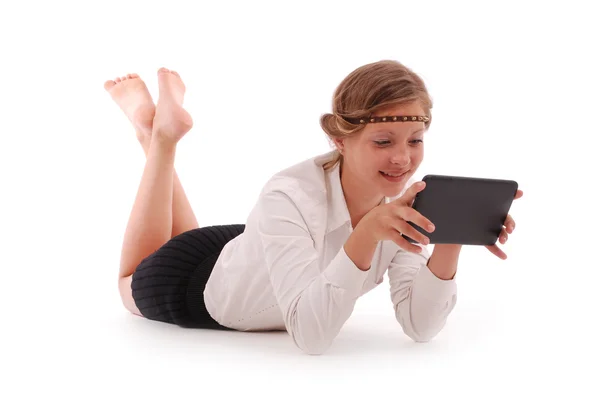 Mädchen schaut im Liegen auf Tablet-PC — Stockfoto