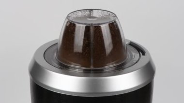 Kahve elektrikli kahve öğütücüsünde ezilir. Beyaza yakın çekim. Yukarıdan bak. 4k. 