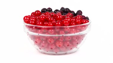 Amelanchier ve kırmızı frenk üzümü cam bir tabakta. Döngü hareketi. Yan görüş. Rotasyon 360. 4K UHD video görüntüsü 3840X2160