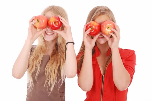 Two girls hold near eyes fresh apples — Stock Photo, Image