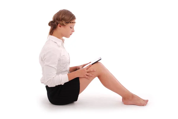 Girl looking at tablet pc while sitting — Stock Photo, Image