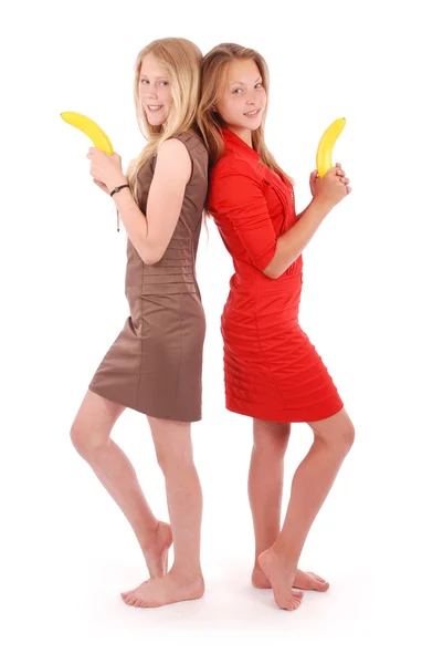 Zwei junge Mädchen halten eine Banane wie eine Waffe — Stockfoto