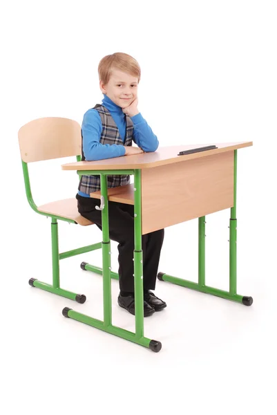 Menino sentado em uma mesa da escola — Fotografia de Stock