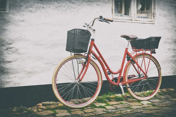 Retro vintage bicicleta vermelha na rua de paralelepípedos na cidade velha . — Fotografia de Stock